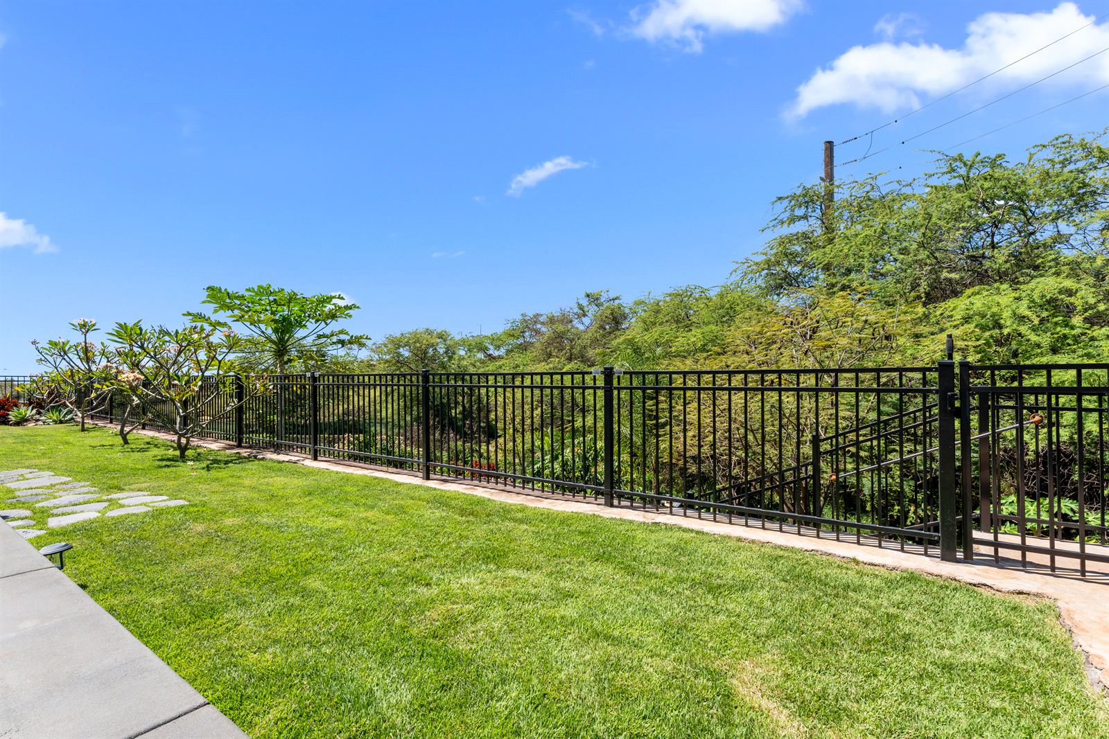 Black aluminum fence around a landscaped yard on Oahu, installed by Upright Fencing Hawaii