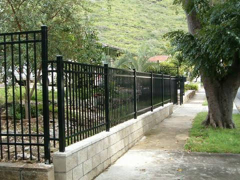 Black aluminum fence on block wall