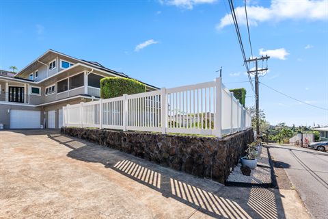 White vinyl semi-privacy fence on a curved lava rock wall, Hawaii