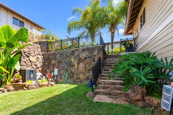 Black aluminum fence and stair railing on a lava rock retaining wall, Oahu