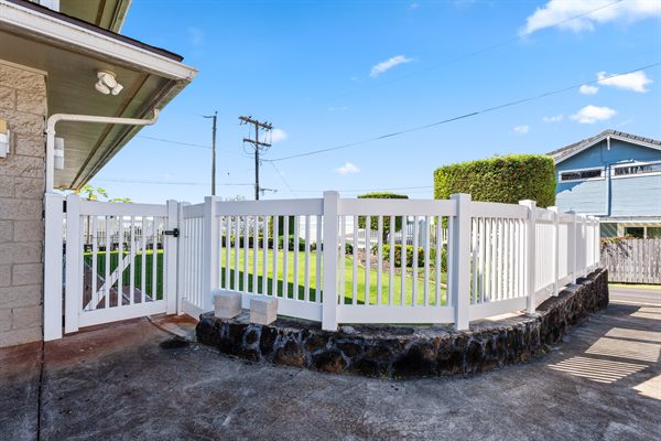 White vinyl semi-privacy fence and walk gate on a lava rock wall, Oahu